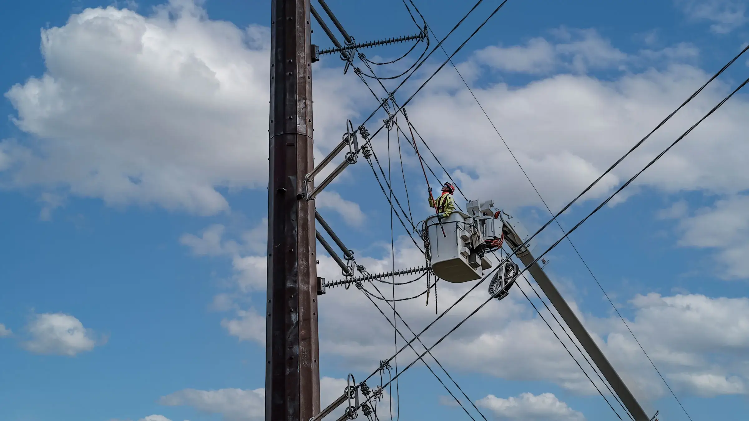 A Morgan Luis Power crew member operates on a power line from a bucket