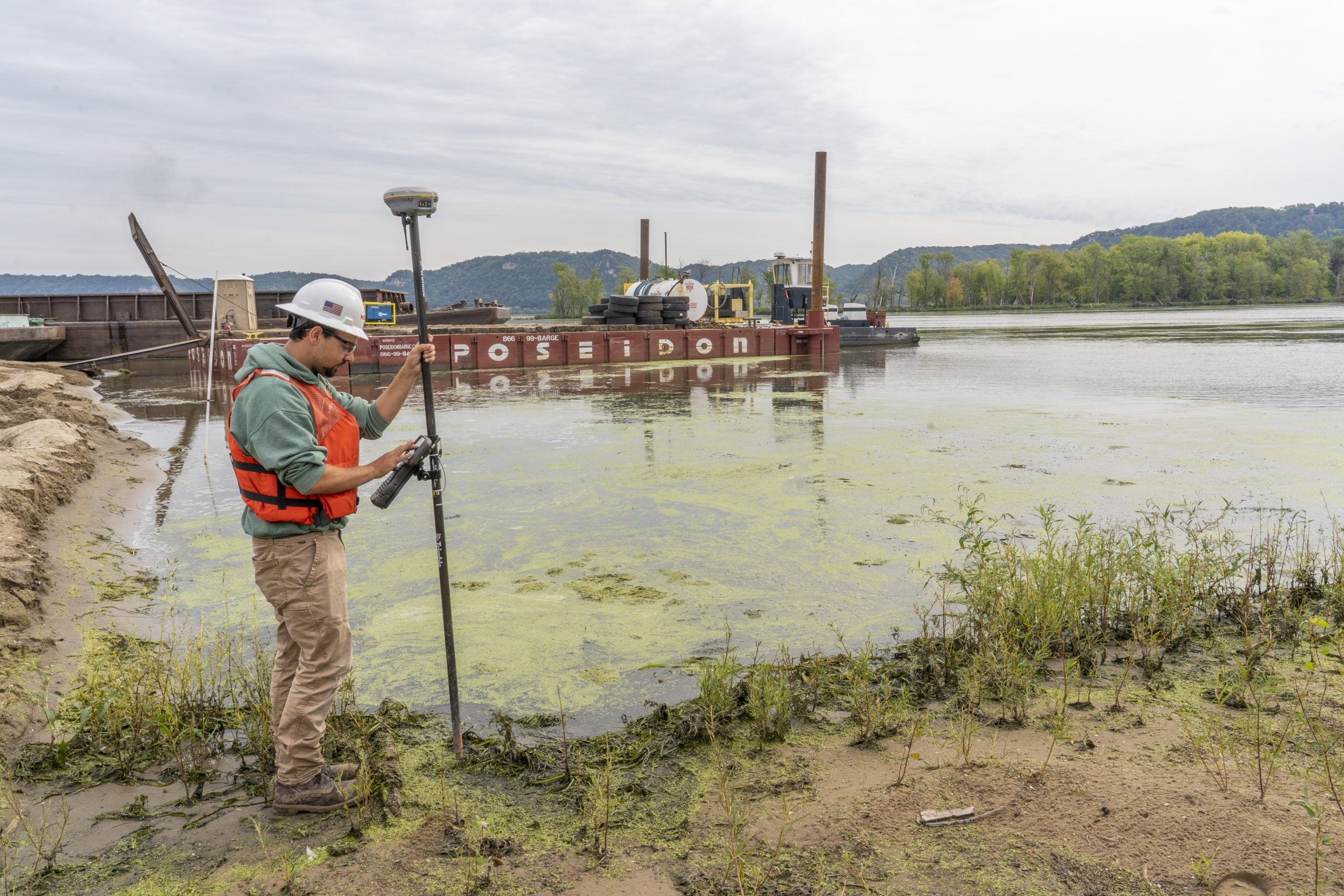 A worker works at the edge of the Upper Mississppi River.