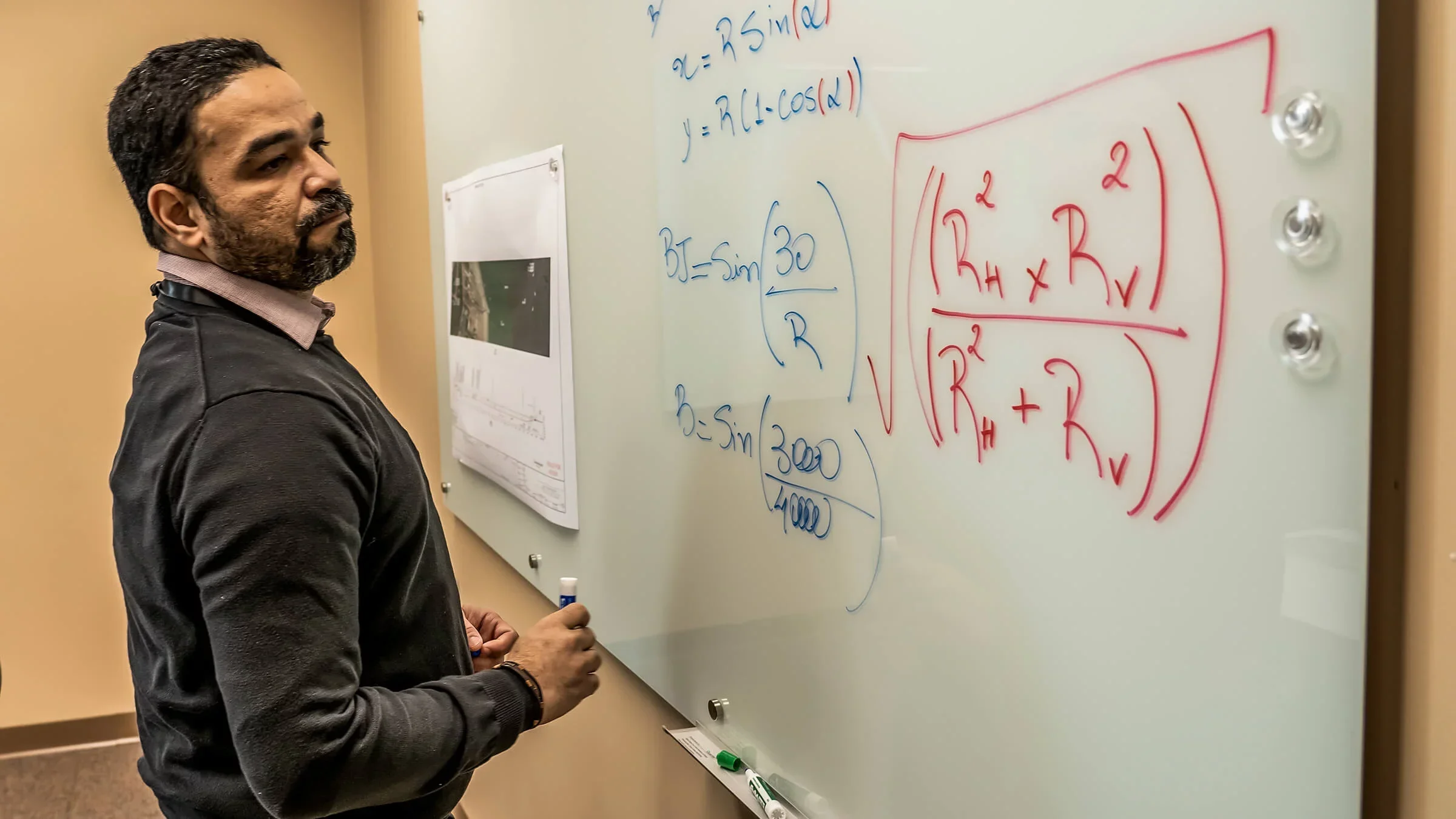 Man writes calculations on a whiteboard