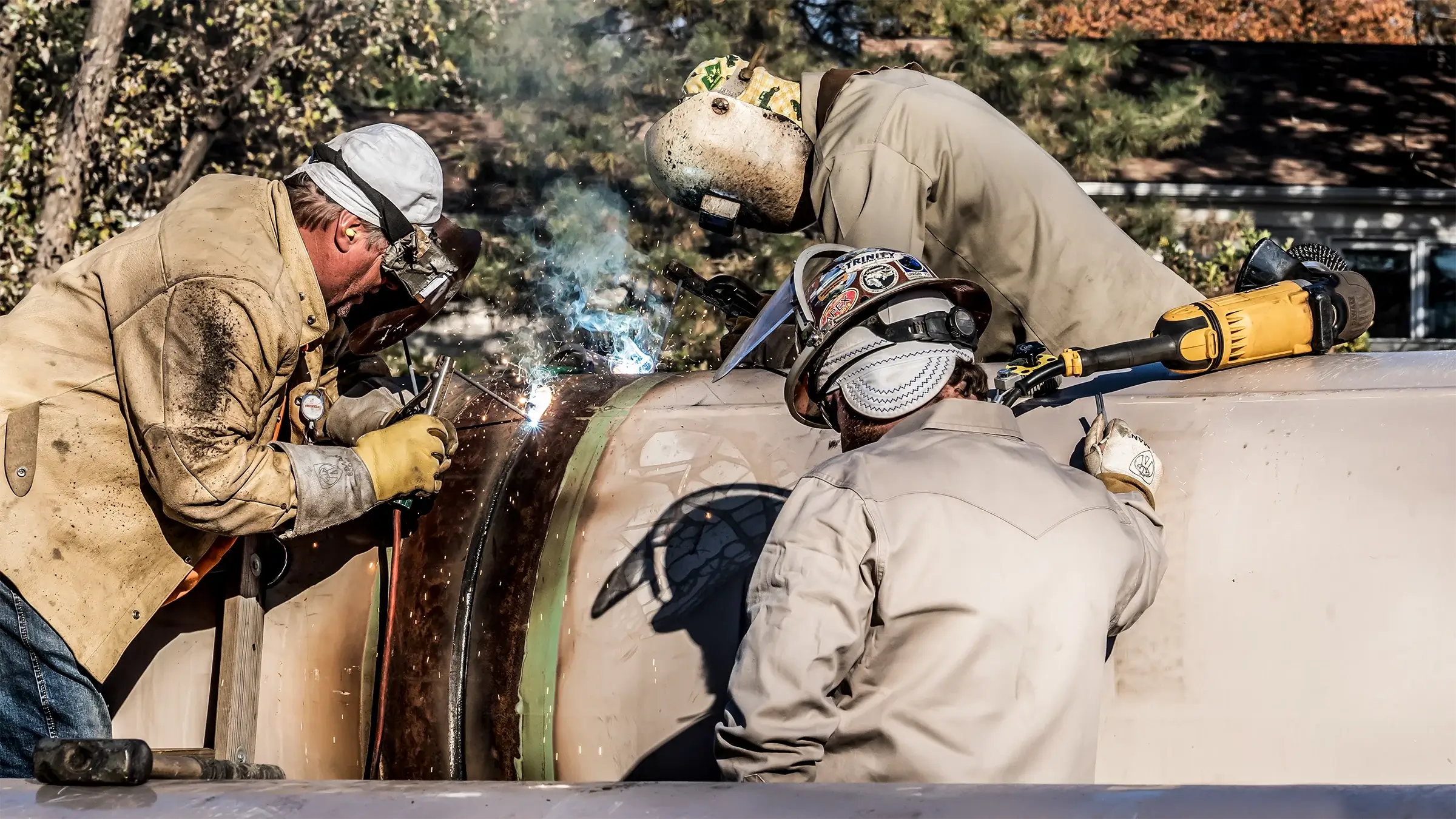 Three people weld a large diameter casing pipe for a Direct Pipe project