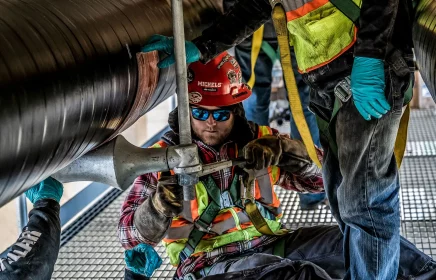 Michels Utility Services crew fastens natural gas pipelines under bridge in Minneapolis Minnesota
