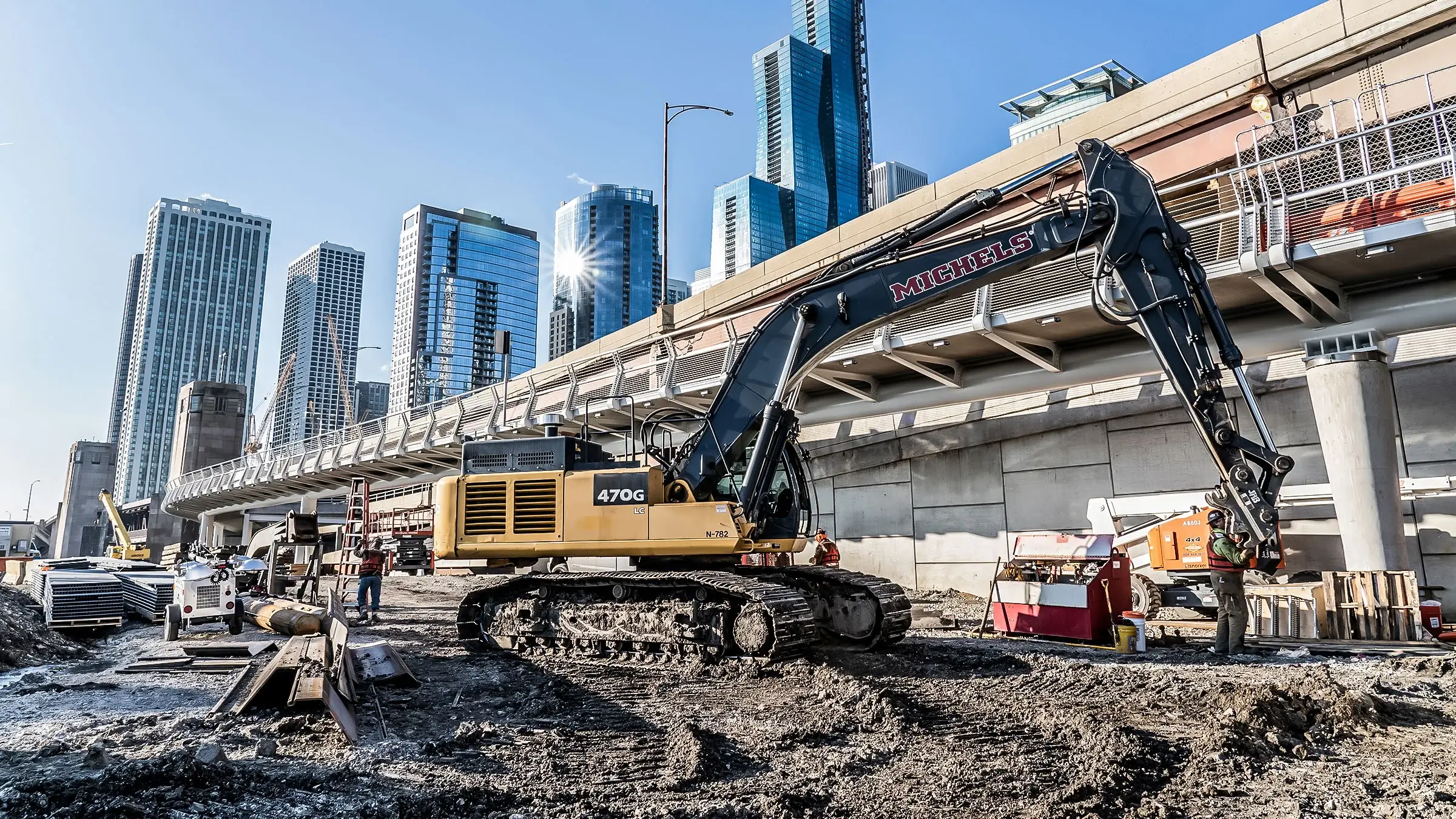 A Morgan Luis excavtor near a Chicago bridge and skyscrapers