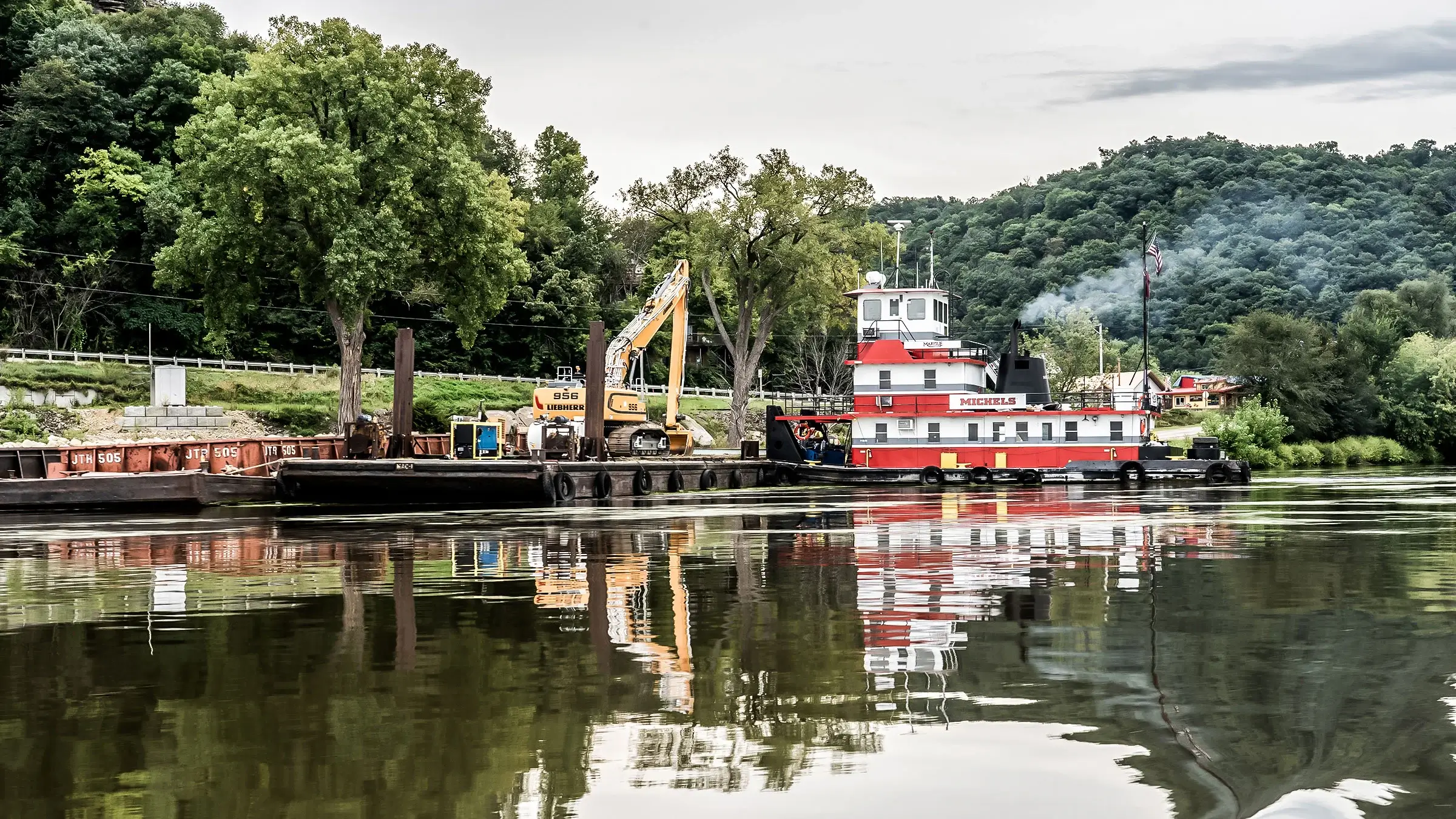 Barge carrying excavator and other equipment moves to begin work on Harpers Slough Island
