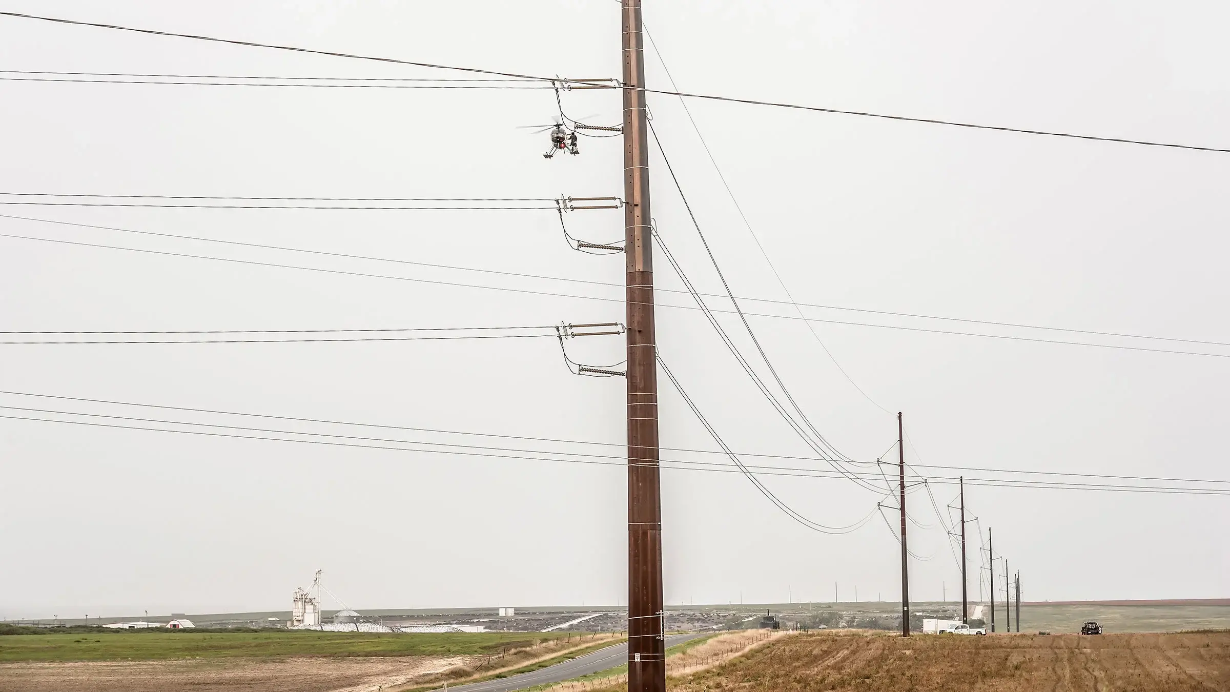 A helicopter assits in operating on a power line