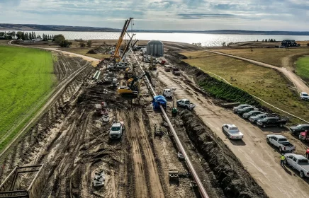 A large pipe is installed under a river through the HDD method of construction.