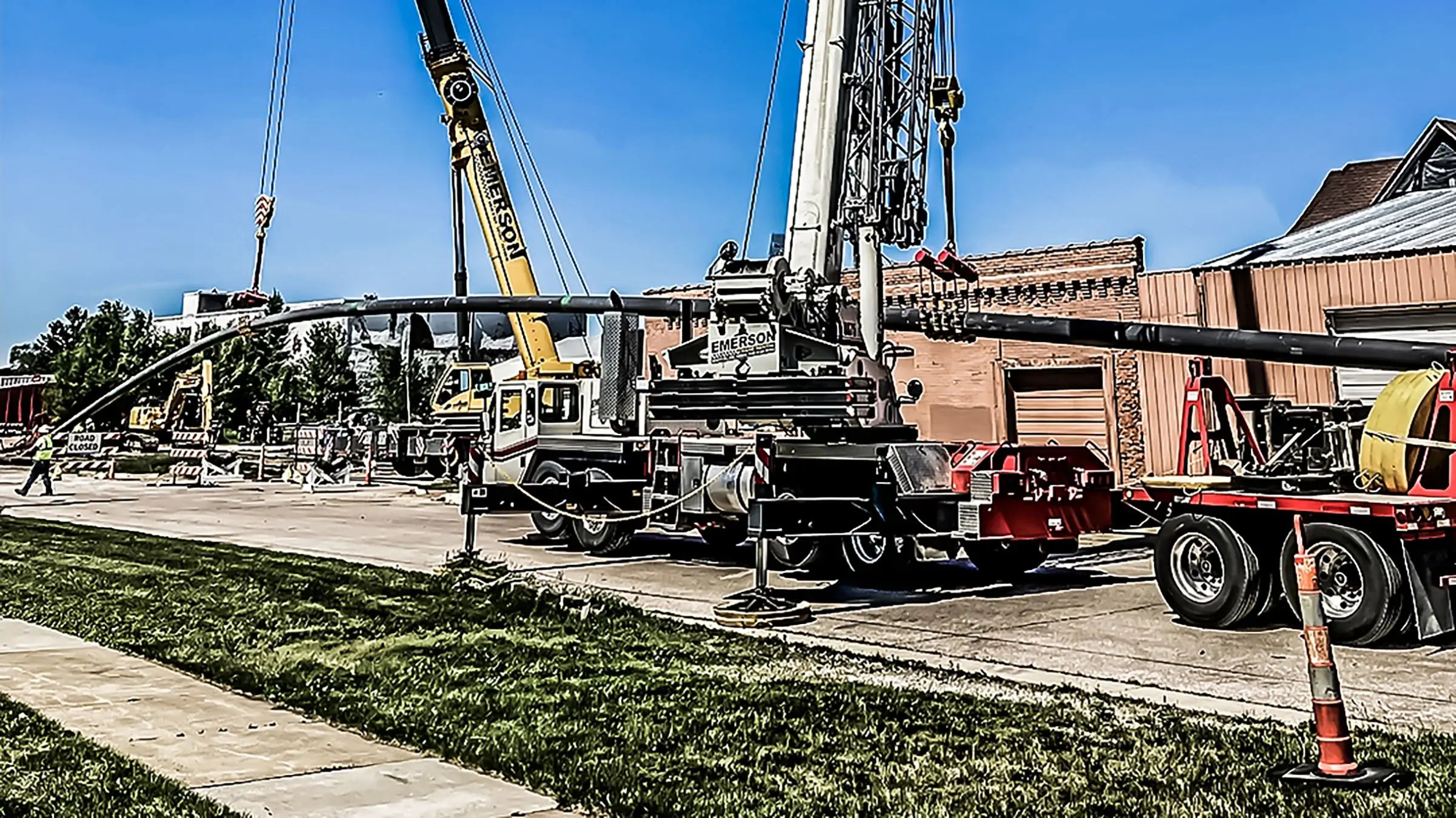 Several cranes assist in guiding pipeline into ground