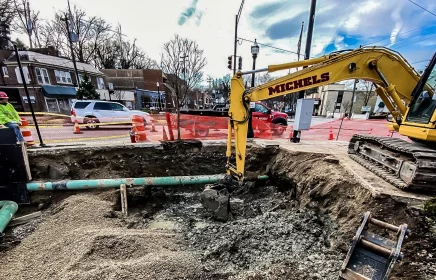 A trackhoe operates in an urban environment