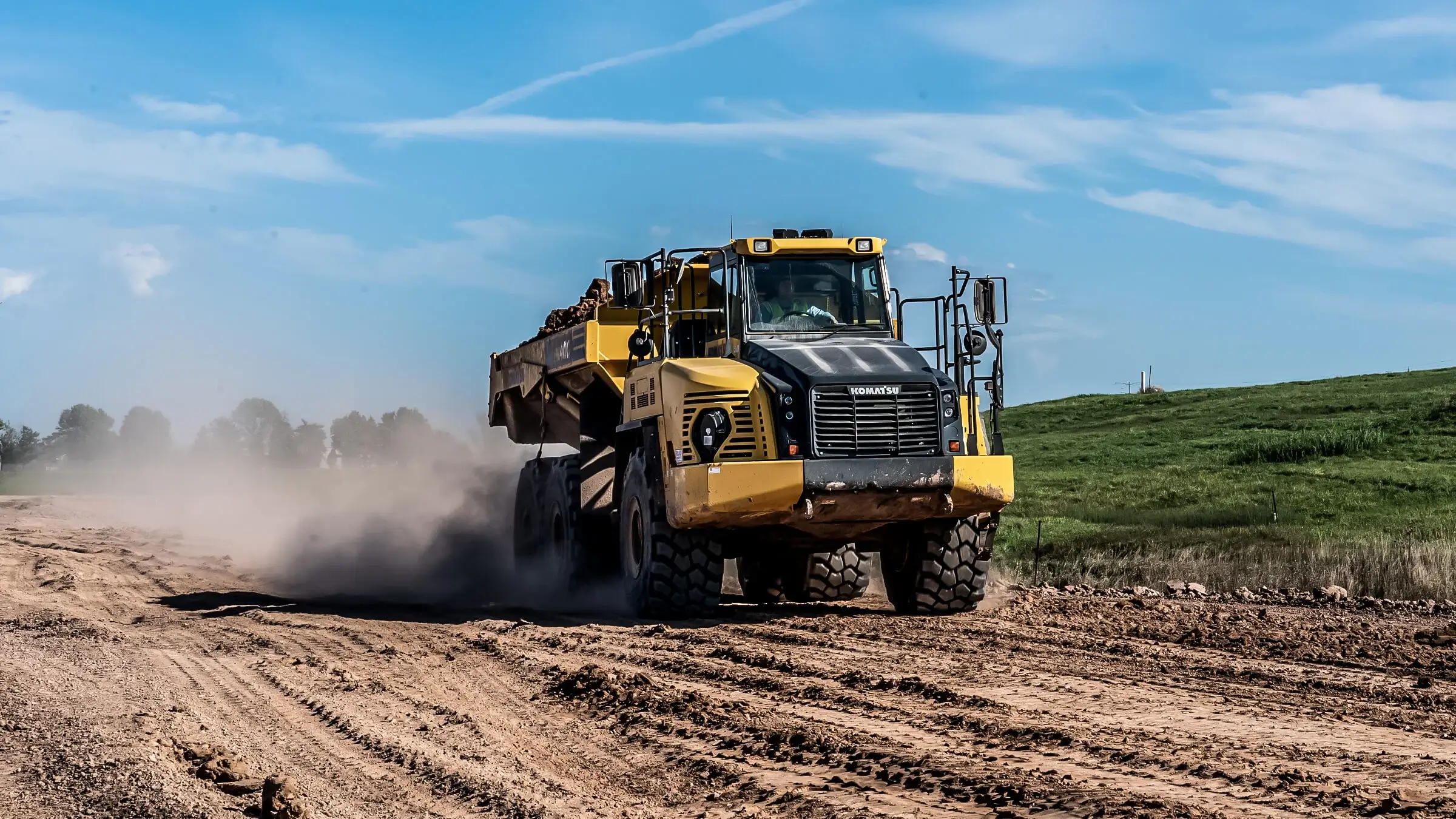 A loader hauls excavated material to a disposal site