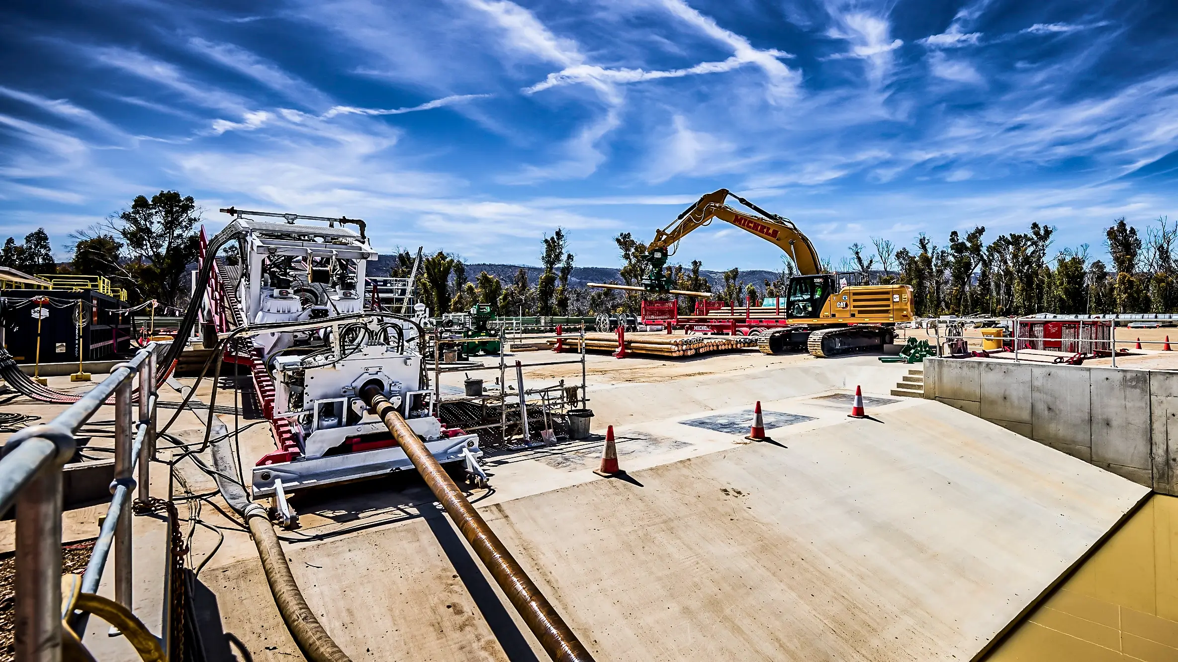An HDD rig operates near an excavator.