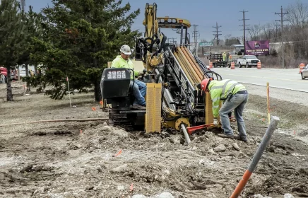 A cable boring machine operates near a busy roadway