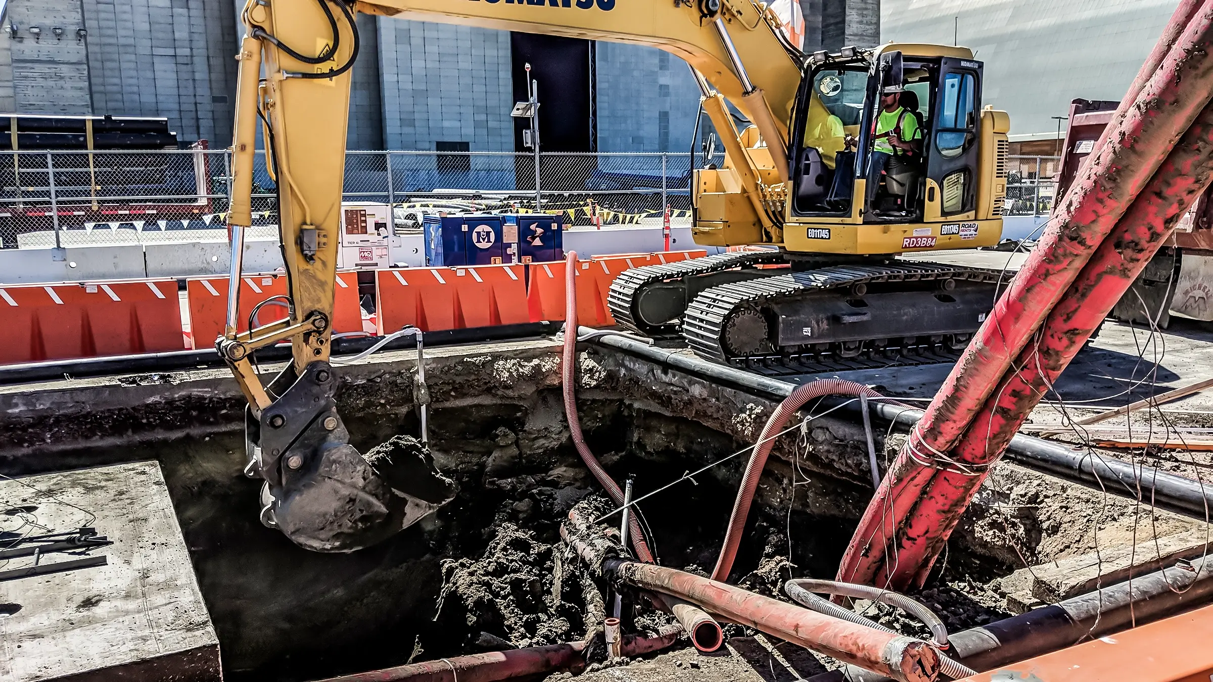 An excavator clears out a section of cleared ground for cable to go into.