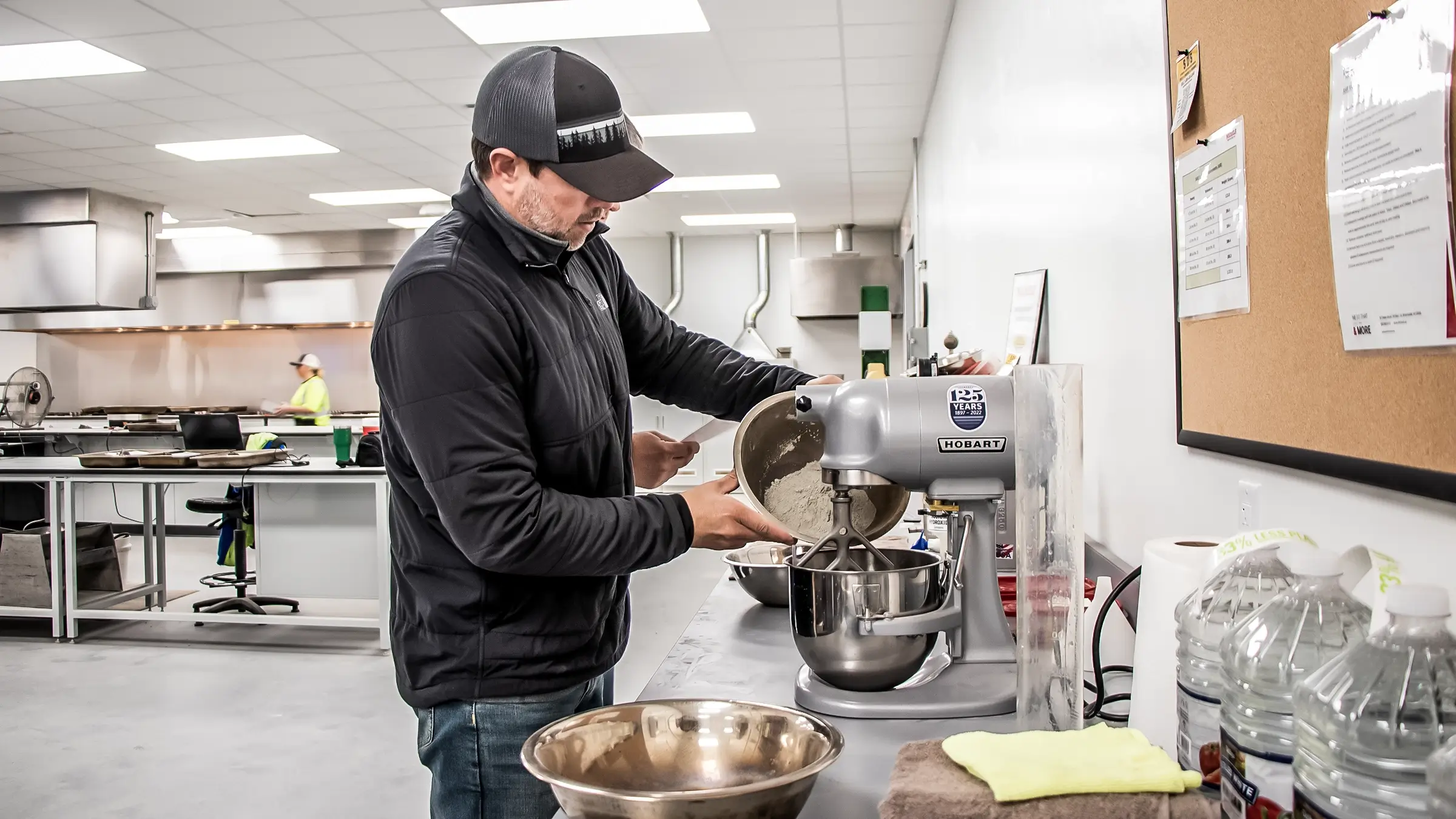 Man mixes aggregate material in a mixing bowl.