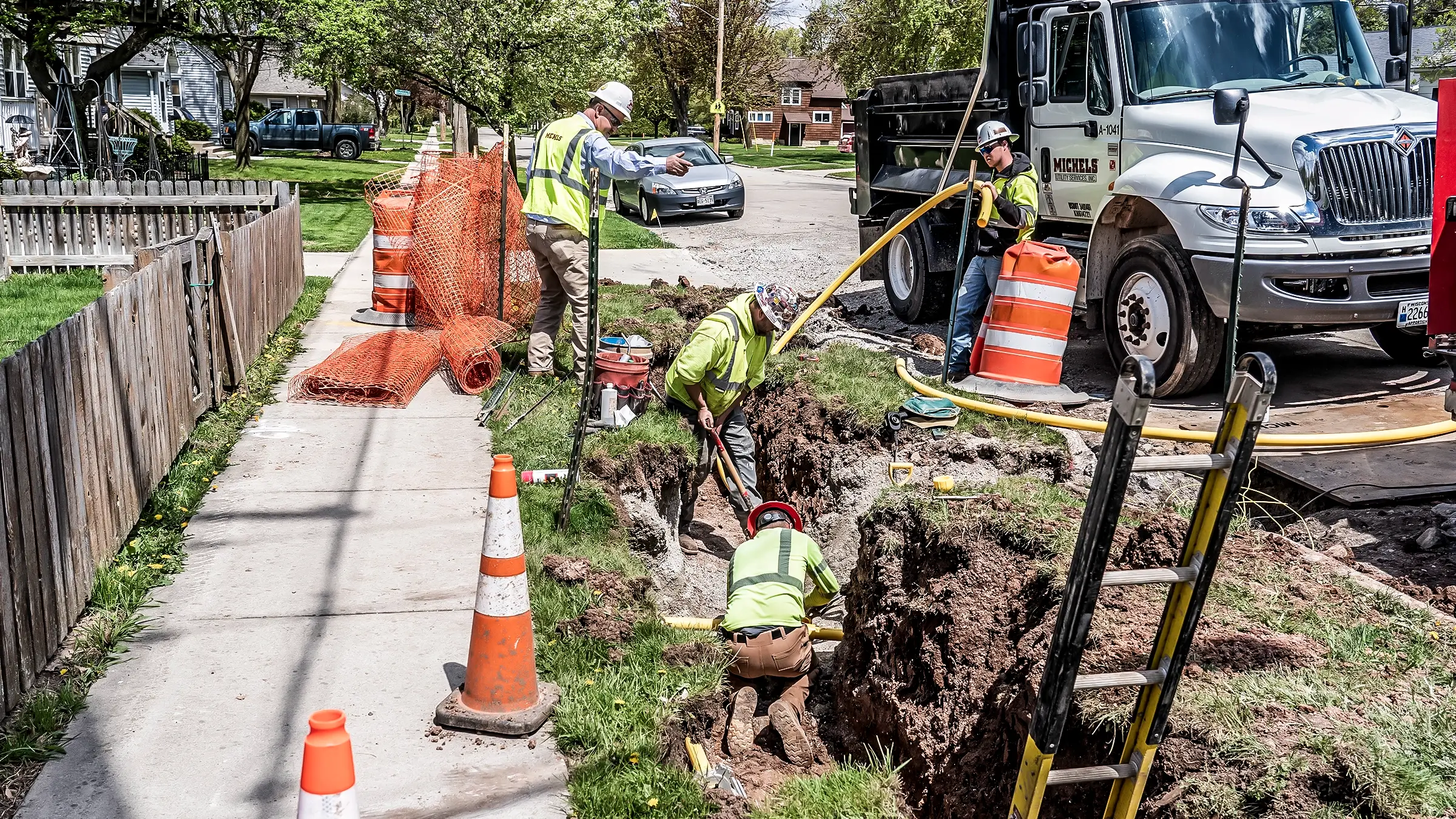 Several crew members work near a road on a small diameter gas pipeline project.