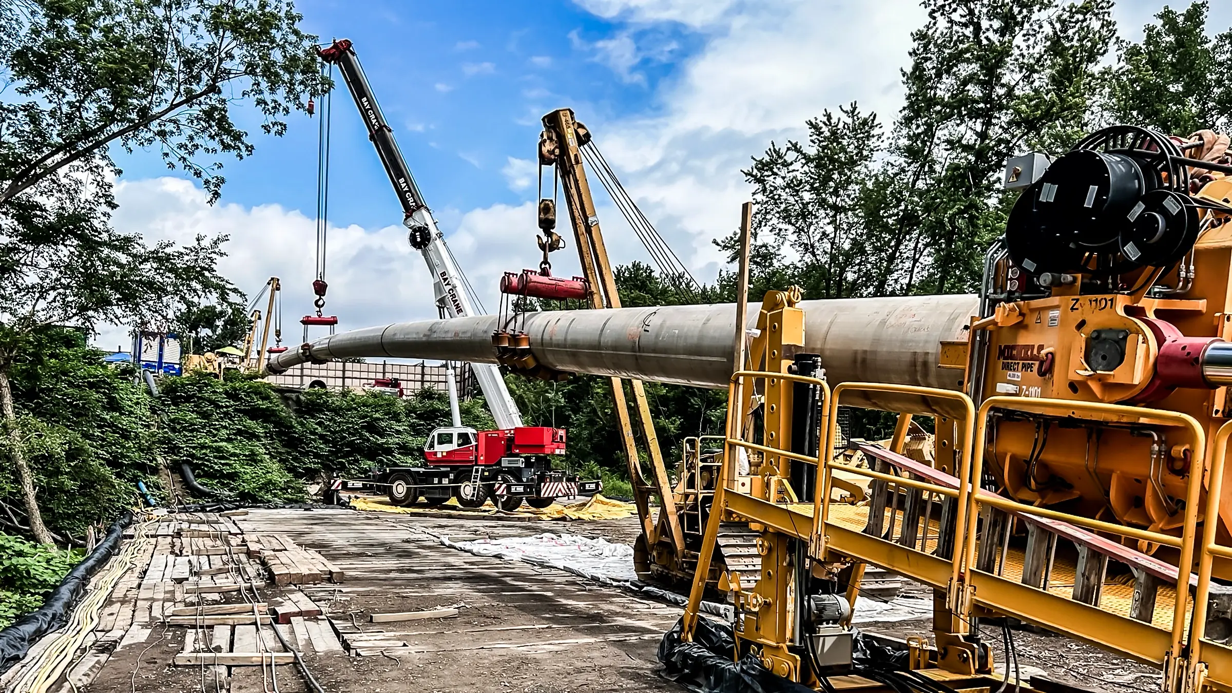 A Direct Pipe thursting machine works with pipelayers and crane to assist pipe on proper path for installation.