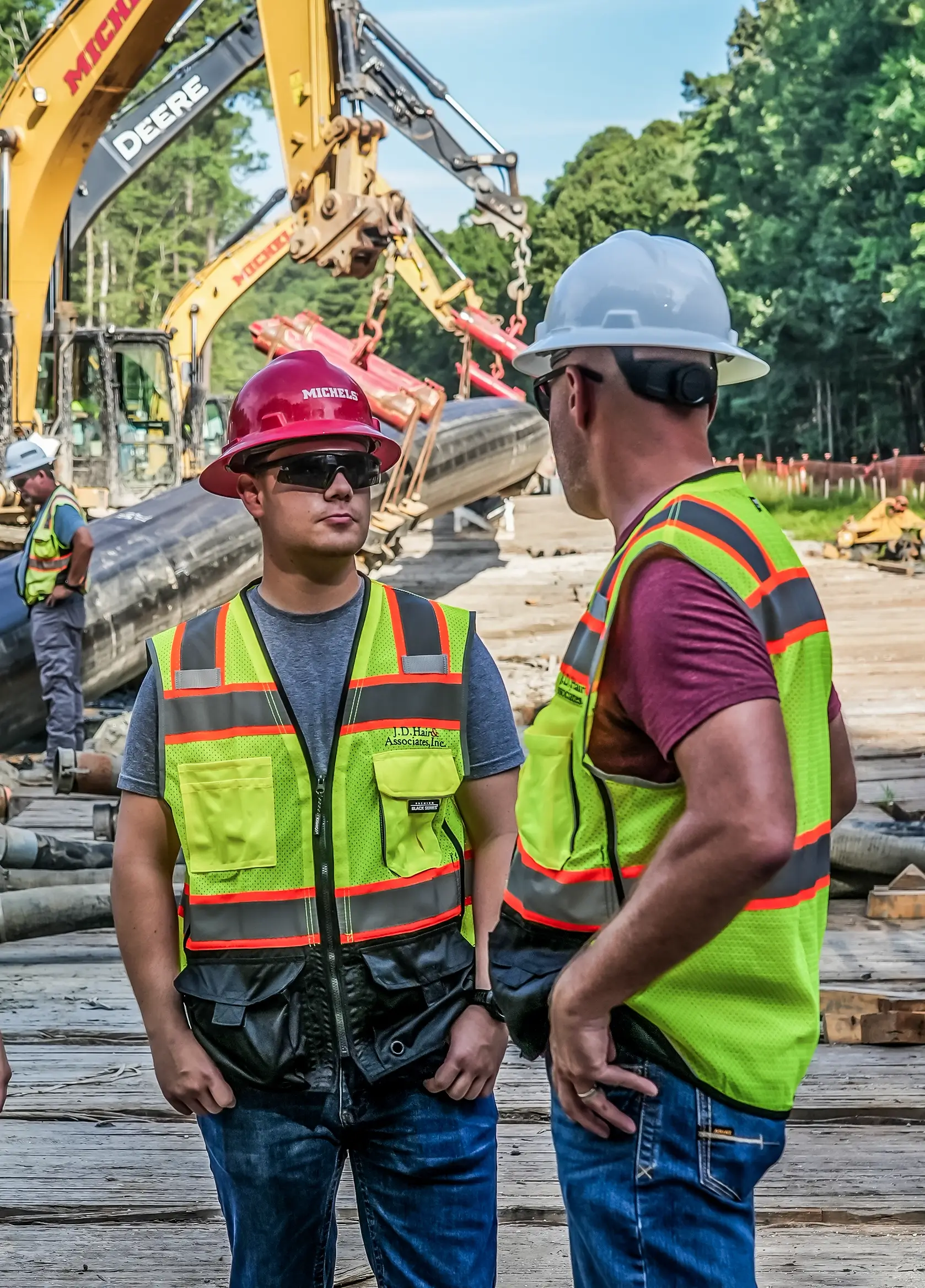 Talk men wearing construction PPE talk on a pipeline jobsite.